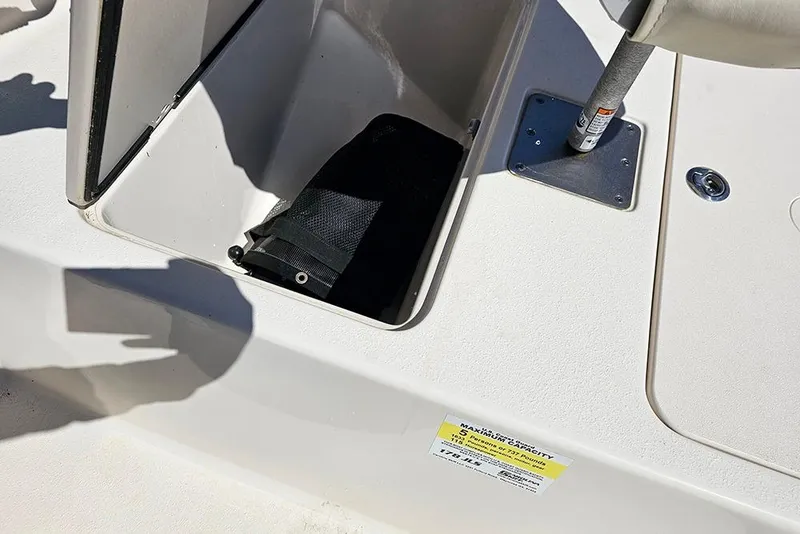 Slide: The Image of 2022 Carolina Skiff 178 JLS boat storage compartment with open hatch and visible interior. - 11