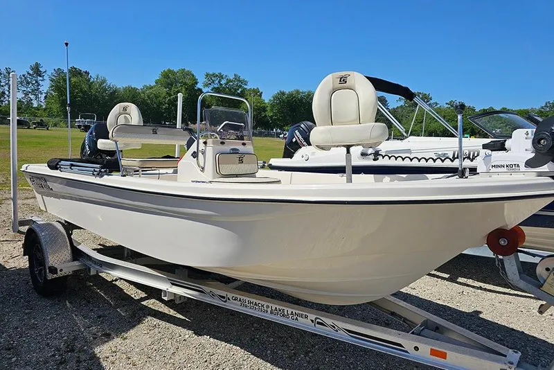 Slide: The Image of 2022 Carolina Skiff 178 JLS boat on trailer, parked outdoors under clear blue sky. - 3