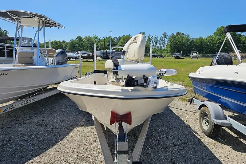 Slide: The Image of 2022 Carolina Skiff 178 JLS boat on trailer, parked outdoors under clear blue sky. - 5