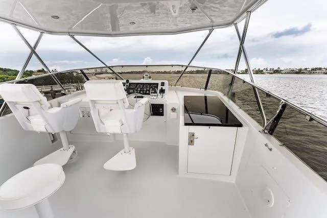 Slide: The Image of Outdoor dining area on 1999 Hatteras 74 Sport Deck Motor Yacht with striped chairs. - 17
