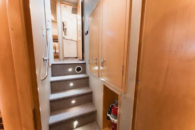 Slide: The Image of Interior of 1999 Hatteras 74 Sport Deck Motor Yacht with wooden stairs and seating area. - 37