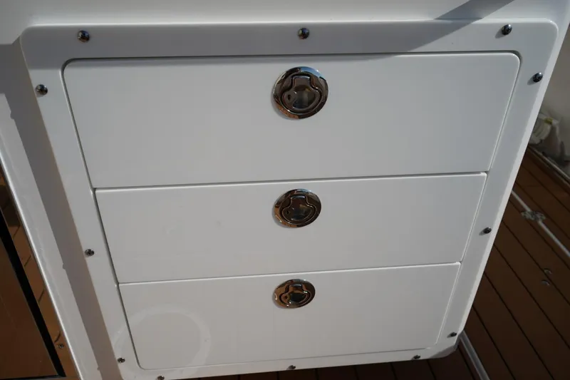 Slide: The Image of 2024 Edgewater 285CC boat storage drawers with sleek metal handles. - 10