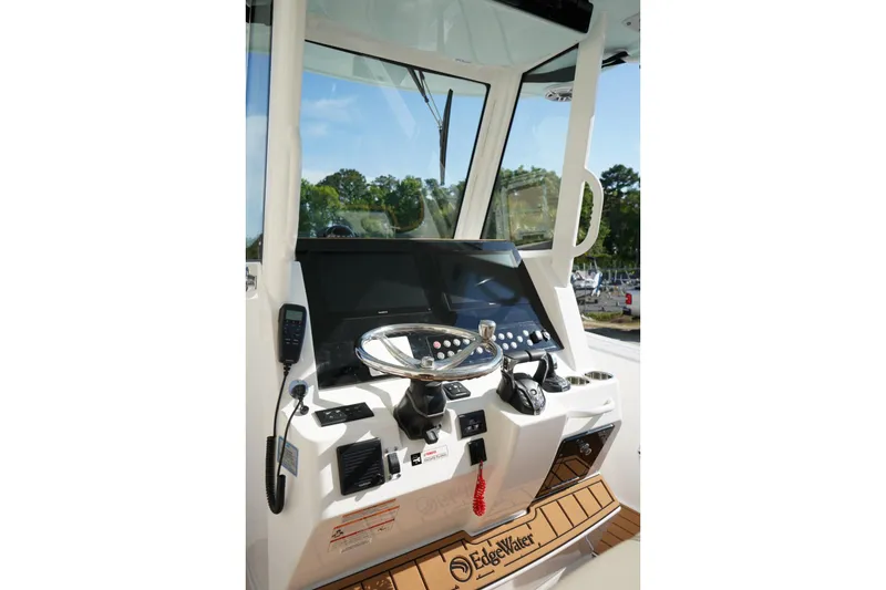 Slide: The Image of 2024 Edgewater 285CC boat cockpit with modern steering and navigation controls. - 18