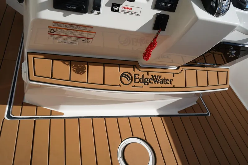 Slide: The Image of 2024 Edgewater 285CC boat deck with logo and control panel. - 21