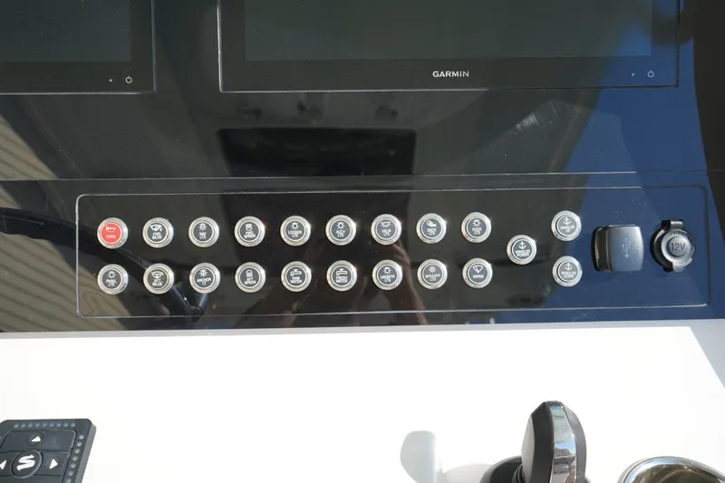 Slide: The Image of Control panel of 2024 Edgewater 285CC boat with various buttons and Garmin displays. - 23