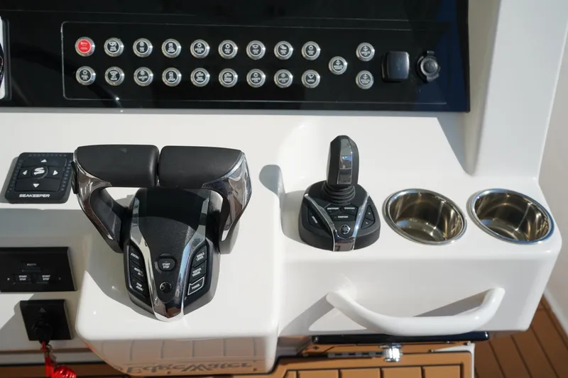 Slide: The Image of 2024 Edgewater 285CC boat console with controls and cup holders. - 25