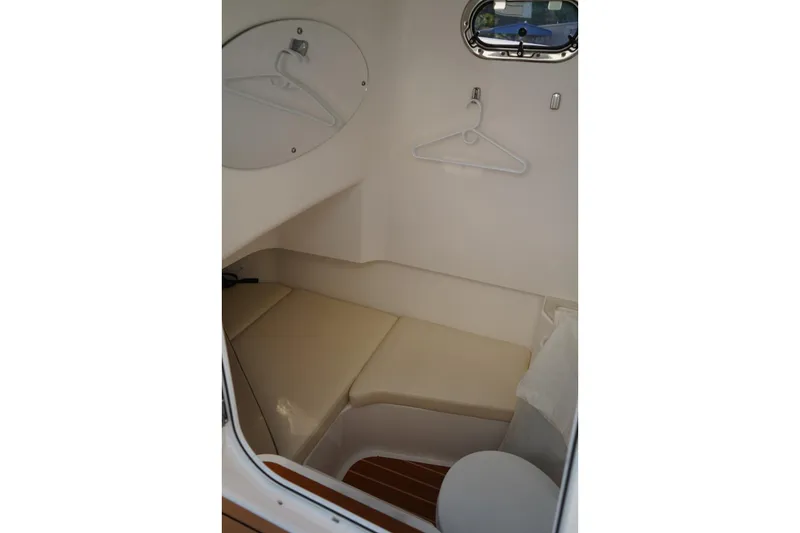 Slide: The Image of 2024 Edgewater 285CC cabin interior with seating and porthole window. - 30