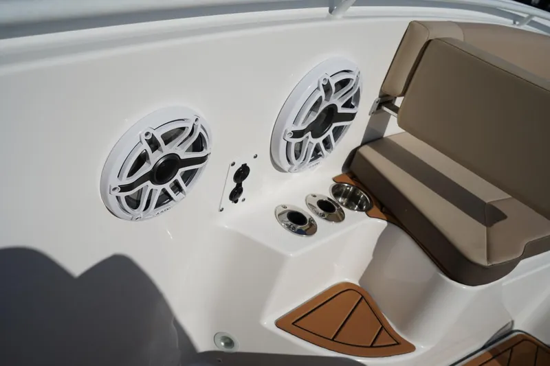 Slide: The Image of 2024 Edgewater 285CC boat interior with speakers, cup holders, and cushioned seating. - 32
