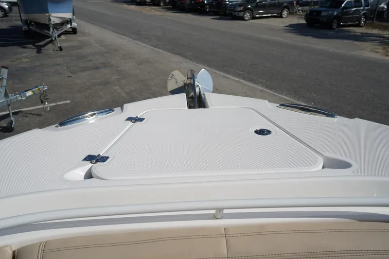 Slide: The Image of 2024 Edgewater 285CC boat deck with storage hatch and anchor, parked on a lot. - 34