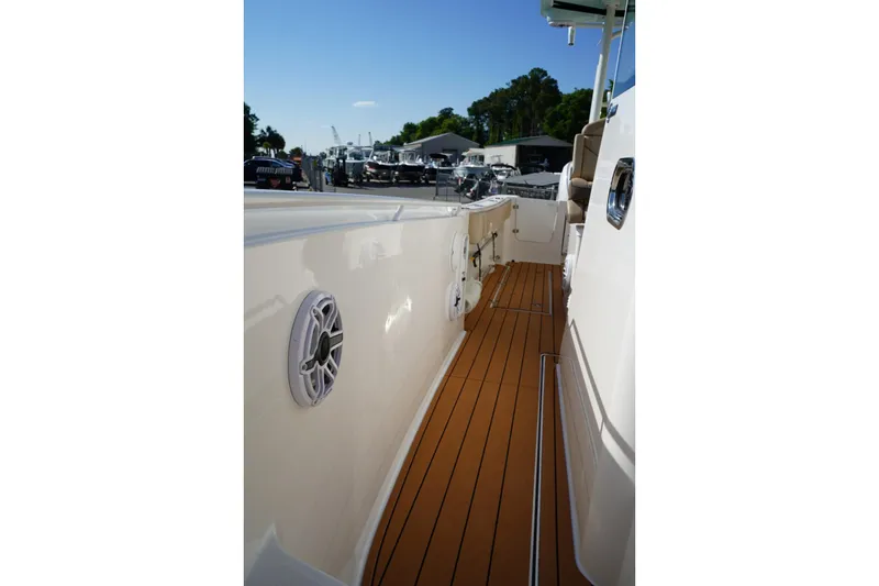 Slide: The Image of 2024 Edgewater 285CC boat deck with teak flooring and speaker detail. - 36