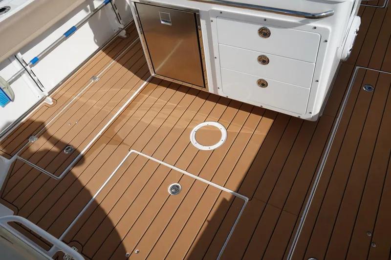 Slide: The Image of 2024 Edgewater 285CC boat deck with teak flooring and storage compartments. - 4