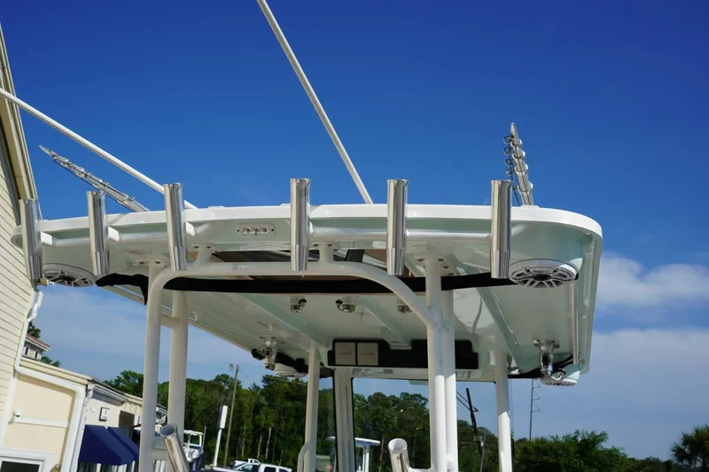 Slide: The Image of 2024 Edgewater 285CC boat with rod holders and speakers under a clear blue sky. - 42