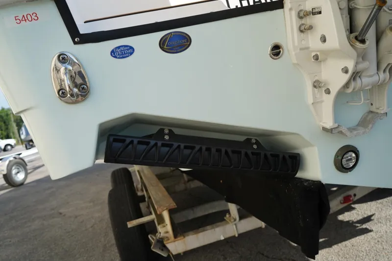 Slide: The Image of 2024 Edgewater 285CC boat transom with warranty badge and trailer visible. - 43