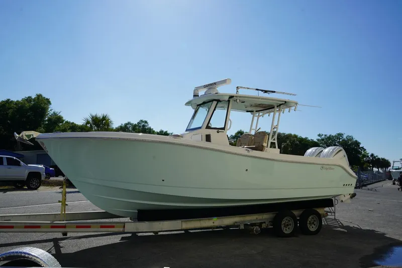 Slide: The Image of 2024 Edgewater 285CC boat on trailer under clear blue sky. - 44