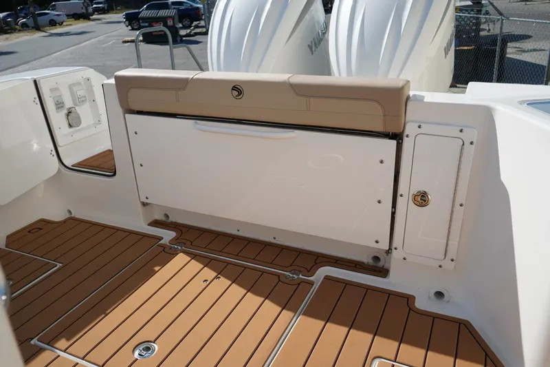 Slide: The Image of 2024 Edgewater 285CC boat interior with teak flooring and cushioned seating. - 8