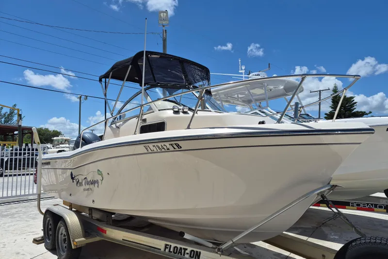 The Image of 2022 Grady-White Adventure 208 boat on trailer under clear blue sky. - 0