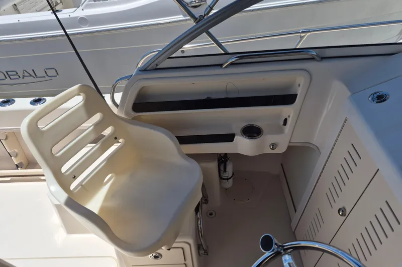 Slide: The Image of 2022 Grady-White Adventure 208 boat helm with white captain's chair and steering wheel. - 11