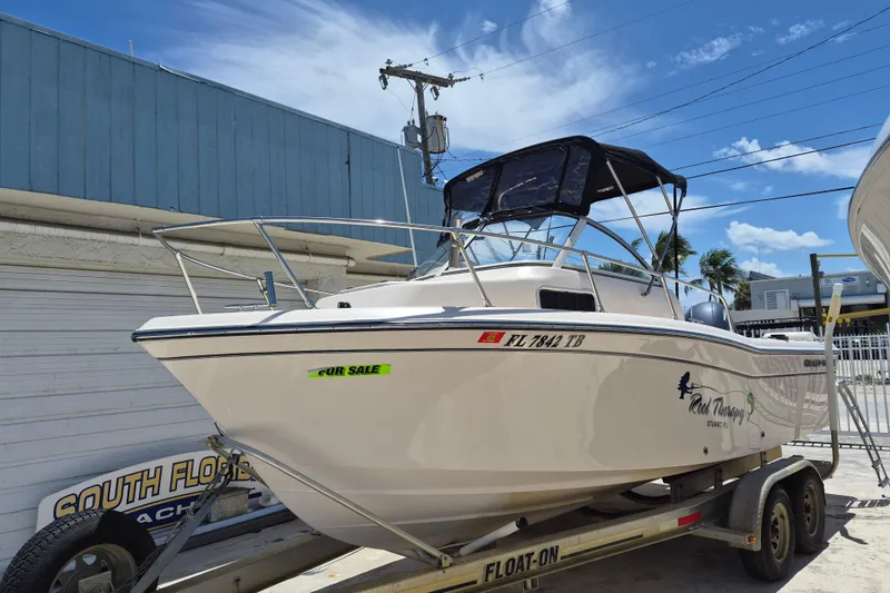Slide: The Image of 2022 Grady-White Adventure 208 boat for sale on trailer, sunny day, blue sky background. - 2