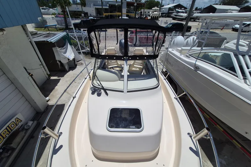 Slide: The Image of 2022 Grady-White Adventure 208 boat with canopy, docked in a marina. - 3