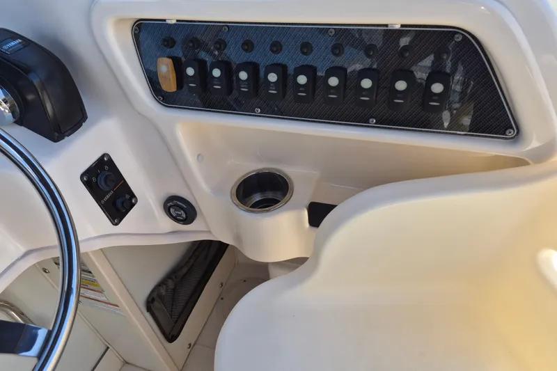 Slide: The Image of Control panel of 2022 Grady-White Adventure 208 boat with switches and steering wheel. - 8