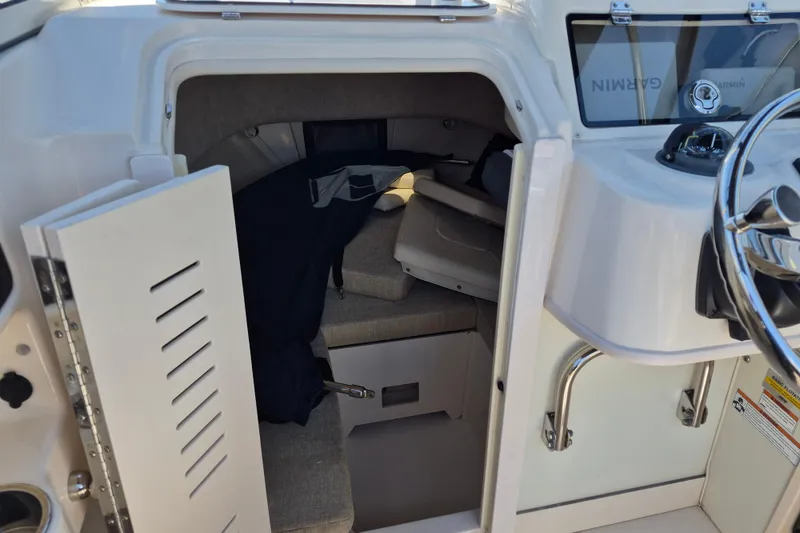 Slide: The Image of 2022 Grady-White Adventure 208 cabin interior with seating and storage. - 9