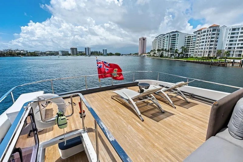 Slide: The Image of 2018 Ferretti Yachts 850 Motoryacht deck with lounge chairs, overlooking waterfront cityscape. - 15