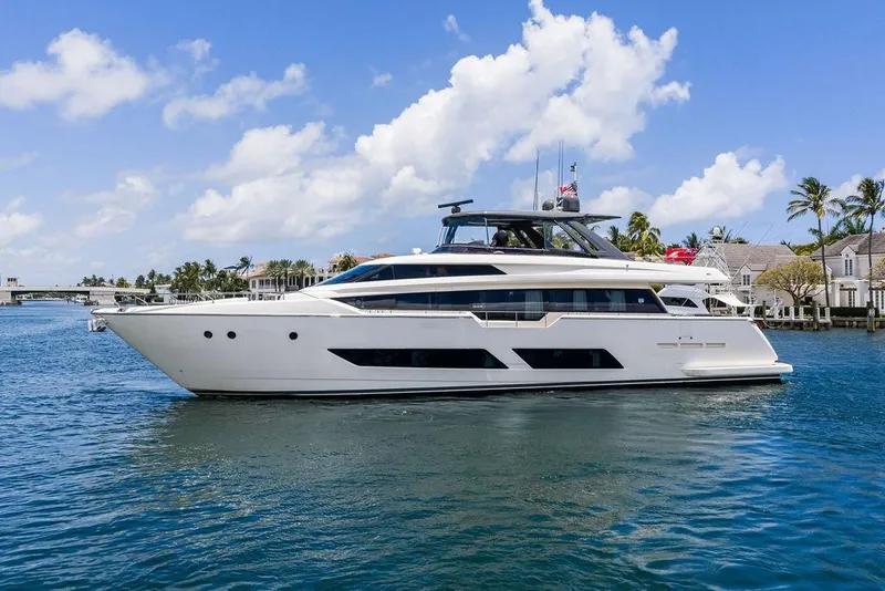 Slide: The Image of 2018 Ferretti Yachts 850 Motoryacht cruising on a sunny day near waterfront homes. - 2