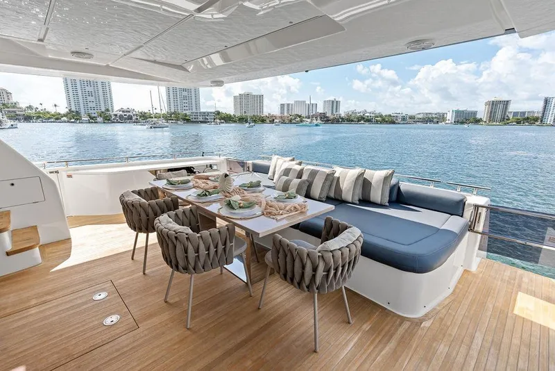 Slide: The Image of Luxurious 2018 Ferretti Yachts 850 Motoryacht deck with elegant dining setup and waterfront view. - 32