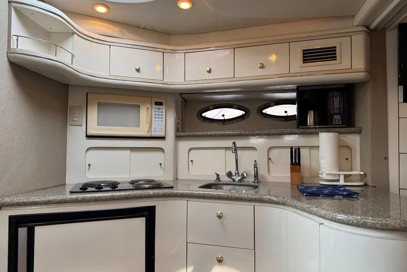 Slide: The Image of 1998 Maxum 4100 SCR yacht kitchen with microwave, stove, and sink. - 10