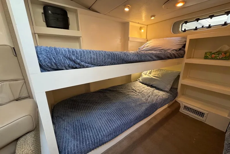 Slide: The Image of 1998 Maxum 4100 SCR yacht interior with cozy bunk beds and storage shelves. - 12
