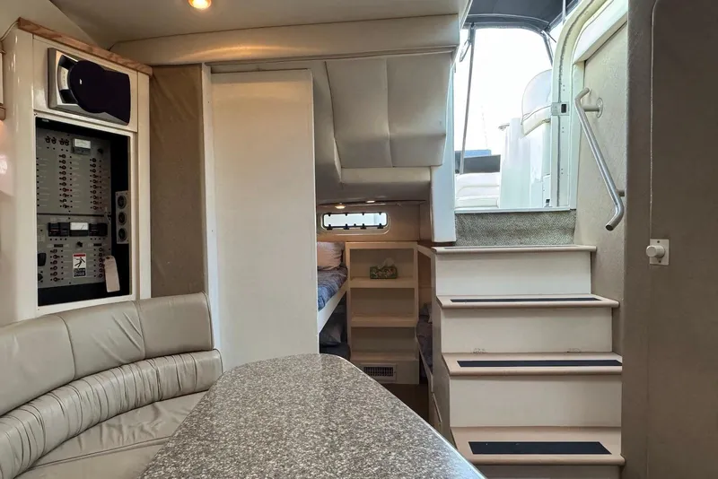 Slide: The Image of Interior of 1998 Maxum 4100 SCR yacht, featuring seating, stairs, and control panel. - 8