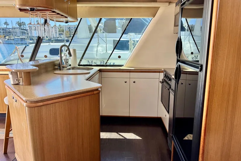 Slide: The Image of 2001 Bayliner 4788 Pilot House Motoryacht kitchen interior with wood cabinetry and modern appliances. - 11