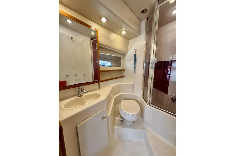 Slide: The Image of Bathroom interior of 2001 Bayliner 4788 Pilot House Motoryacht, featuring sink, toilet, and shower. - 15