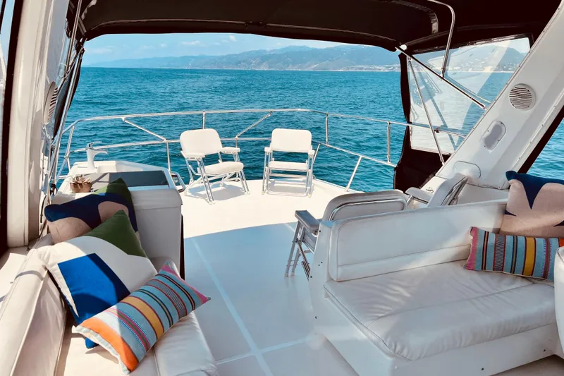 Slide: The Image of Luxurious 2001 Bayliner 4788 Pilot House Motoryacht deck with seating, ocean view, and colorful cushions. - 4