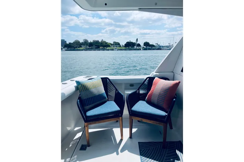 Slide: The Image of Two chairs with colorful cushions on a 2001 Bayliner 4788 yacht, overlooking serene waters. - 5