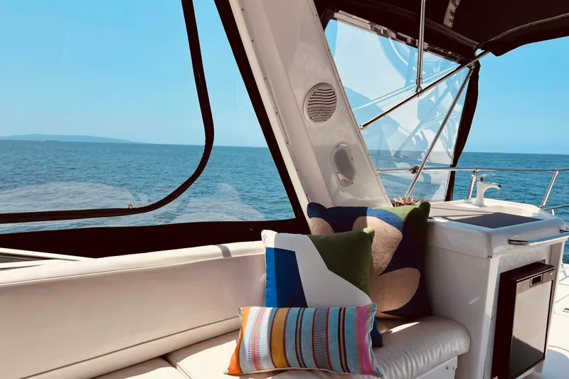 Slide: The Image of Luxurious 2001 Bayliner 4788 Pilot House Motoryacht interior with ocean view and colorful cushions. - 6