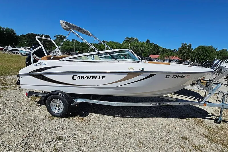 The Image of 2019 Caravelle 17 EBo Bowrider boat on trailer, parked outdoors under clear blue sky. - 1