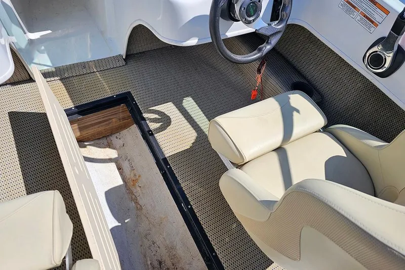 Slide: The Image of Interior of a 2019 Caravelle 17 EBo Bowrider boat with beige seating and storage compartment. - 18
