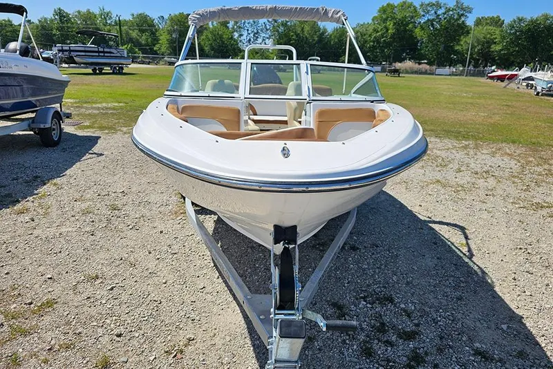 Slide: The Image of 2019 Caravelle 17 EBo Bowrider boat on trailer, parked outdoors. - 4