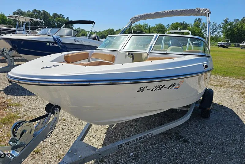 Slide: The Image of 2019 Caravelle 17 EBo Bowrider boat on trailer, parked outdoors. - 5
