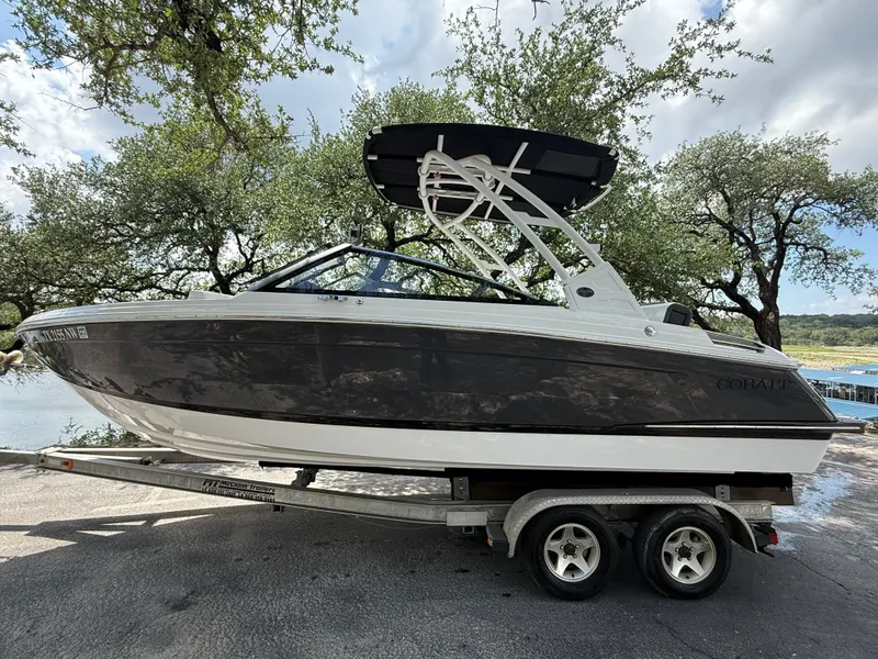 Slide: The Image of 2025 Cobalt R4 boat on trailer, surrounded by trees. - 2