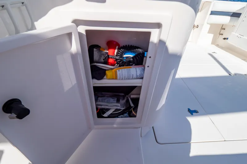 Slide: The Image of Open storage compartment on 2014 Intrepid 375 Walkaround boat, containing various boating essentials. - 105