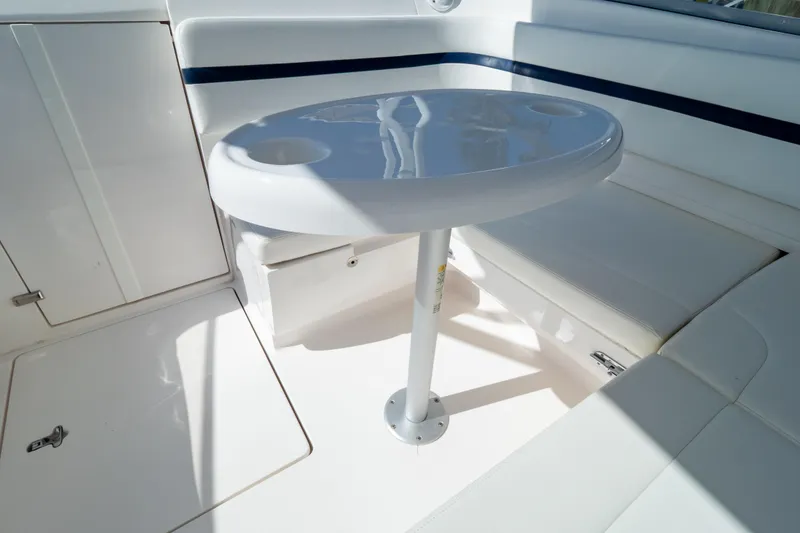 Slide: The Image of 2014 Intrepid 375 Walkaround boat interior with white seating and round table. - 106