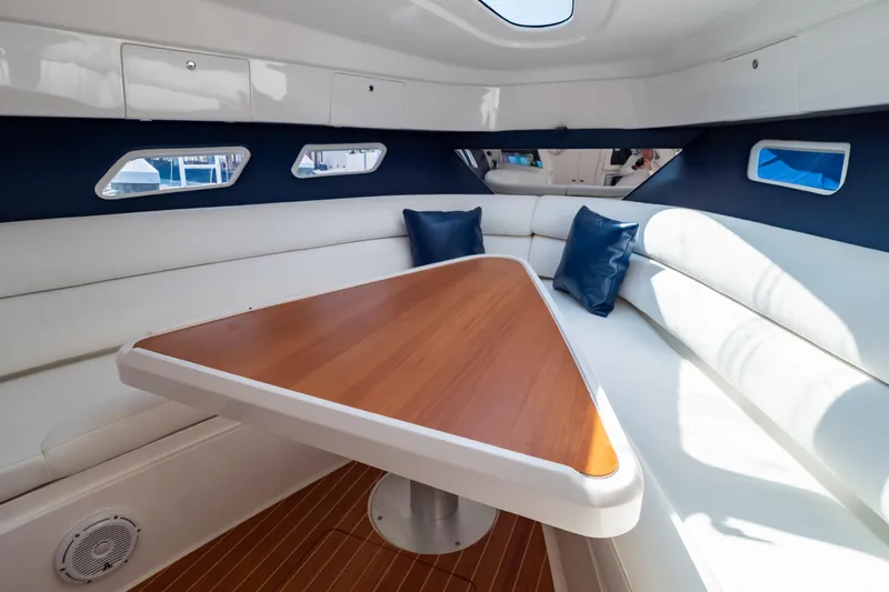 Slide: The Image of Interior of 2014 Intrepid 375 Walkaround with white seating and wooden table. - 11