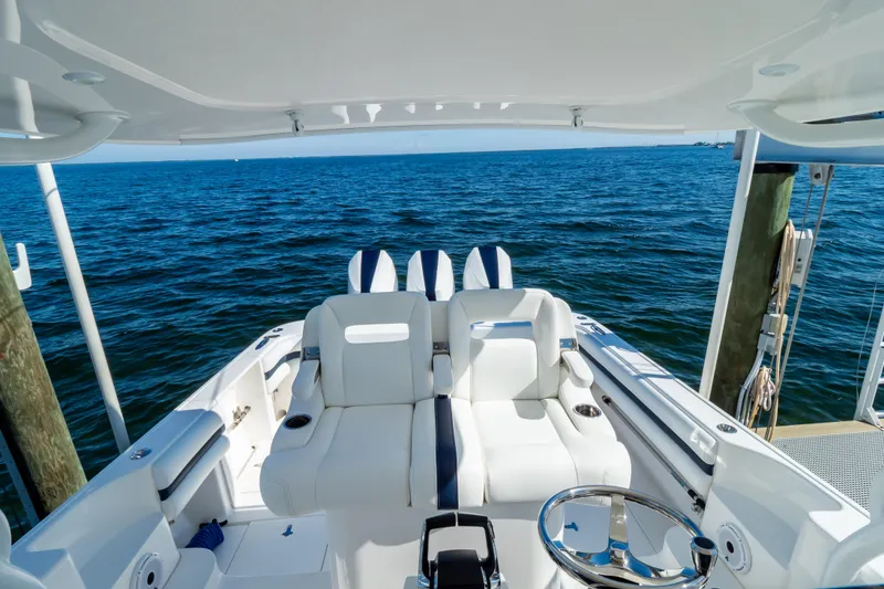 Slide: The Image of 2014 Intrepid 375 Walkaround boat interior with white seating, overlooking the ocean. - 111