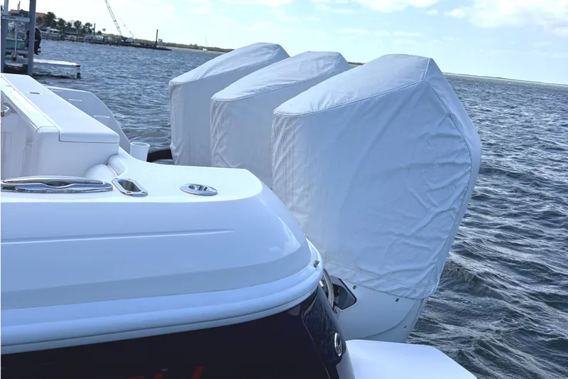Slide: The Image of 2014 Intrepid 375 Walkaround boat with covered outboard motors on a calm sea. - 119