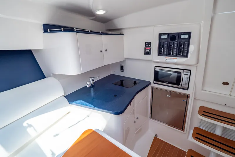 Slide: The Image of 2014 Intrepid 375 Walkaround interior with kitchenette, featuring stove, microwave, and control panel. - 12
