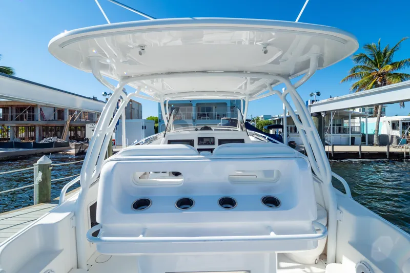 Slide: The Image of 2014 Intrepid 375 Walkaround boat docked, showcasing sleek design and spacious seating area. - 14