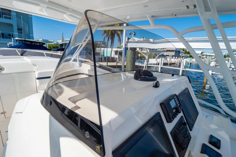 Slide: The Image of 2014 Intrepid 375 Walkaround boat helm with navigation equipment, docked at marina. - 18