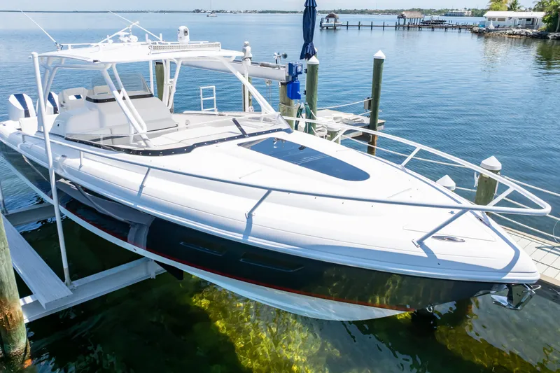 Slide: The Image of 2014 Intrepid 375 Walkaround boat docked on clear waters. - 27